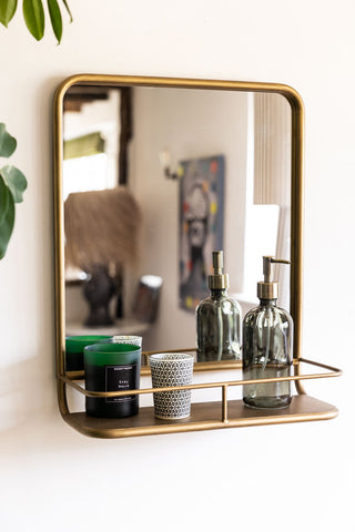 Lifestyle image of the Distressed Gold Metal Mirror With Shelf