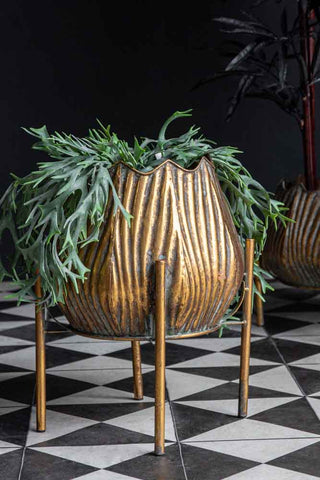 Lifestyle image of the Gold Scallop Planter On Stand