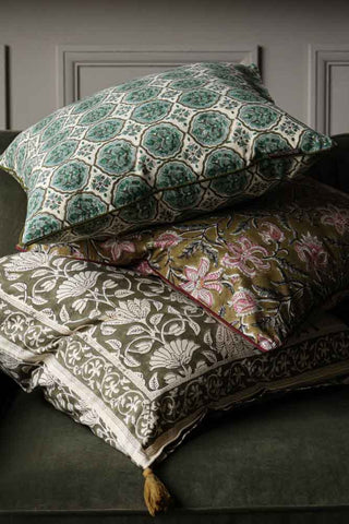 Image of the Green Clover Block Printed Cushion piled on top of other cushions