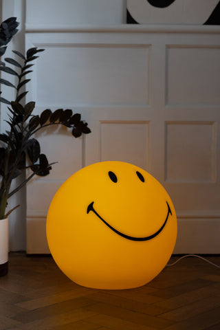 Image of the Smiley Floor Lamp lit up on the floor