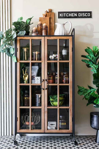 Lifestyle image of the Industrial Style Wooden Display Cabinet On Wheels with both doors closed