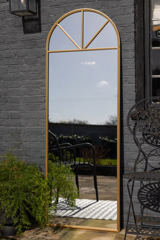 Lifestyle image of the Tall Gold Arched Garden Mirror