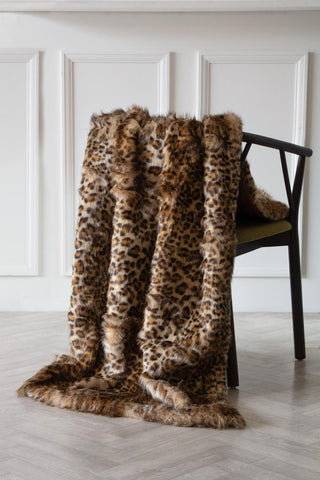 Image of the Light Faux Fur Leopard Print Throw over a chair