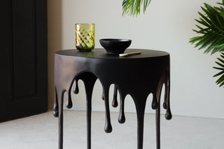 Landscape lifestyle Image of the Matt Black Drip Side Table with green accessories