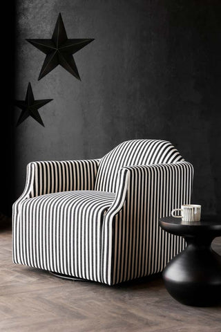 Lifestyle image of the Monochrome Striped Swivel Chair with stars on the wall