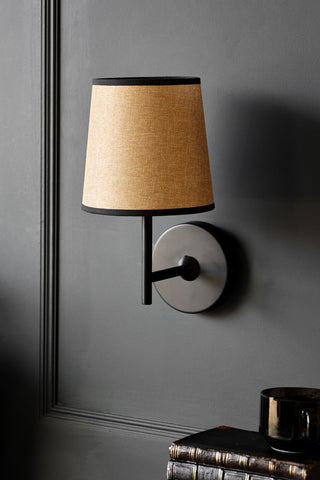 Lifestyle image of the tapered linen shade wall light