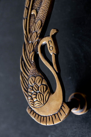 Close up of Set Of Head of Art Deco Brass Swan Door Handles on a cupboard