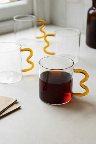 Lifestyle image of the Set of 4 Amber Wavy Handle Glass Mugs