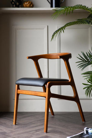 Lifestyle image of the Solid Wood Mid-Century Black Faux Leather Dining Chair