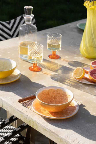 Lifestyle image of all 4 of the orange Grapefruit Plate in a setting