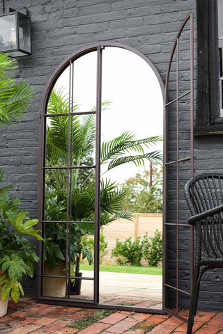 Image of the Tall Black Arch Indoor/Outdoor Window Pane Mirror With Opening Doors with one door open