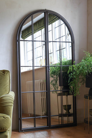 Image of the Tall Black Arch Indoor/Outdoor Window Pane Mirror With Opening Doors indoors