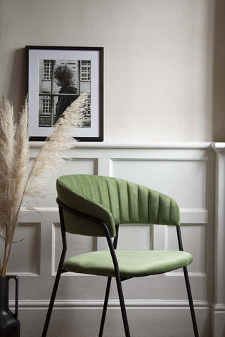 Lifestyle image from the side of the Curved Back Velvet Dining Chair In Moss Green
