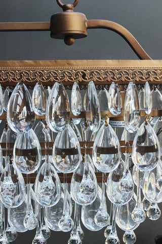 detail image of glass droplets on stunning crystal droplets chandelier with dark wall background