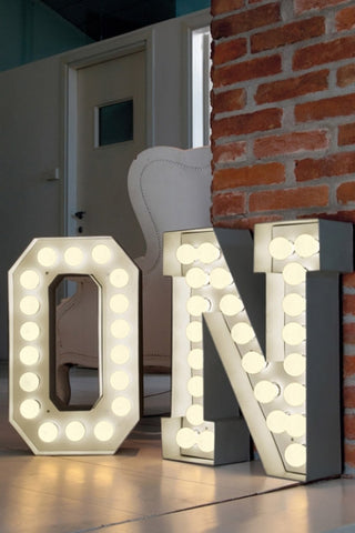 lifestyle image of vegaz style large metal letter with led lights o and n with brick wall in background