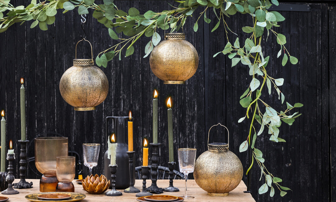 image of brass solar lanterns in an outdoor dining table seting